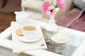 Cup of coffee on table in living room