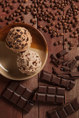 scoops of ice cream, chocolate and coffee on wooden background