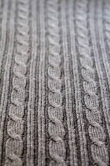 Perspective of three cables on a full frame gray cable knit sweater
