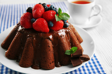 Delicious chocolate cake with strawberries in plate on table, closeup