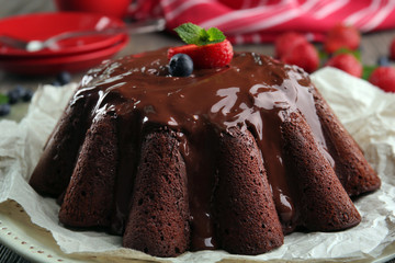 Delicious chocolate cake with berries in plate on table, closeup