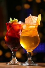 Glasses of cocktail on dark blurred lights background