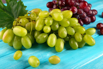 White and red grape on blue wooden background
