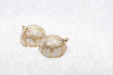 Gold and white baubles in fake snow