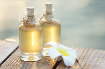 Obraz na płótnie Canvas Bottles of aroma oil with flower outdoors