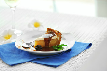 Delicious cake under chocolate glaze with blackberry on blue serviette