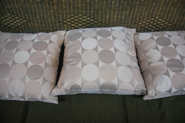 grey pillows on modern rattan sofa
