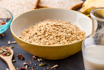 a bowl of oatmeal with milk, grains, and bread
