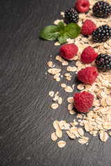 Healthy breakfast and berries on slate background, close-up