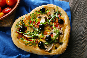 Heart shaped pizza on napkin on wooden table