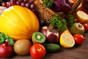 A set of fruit and vegetables in a basket on wooden background