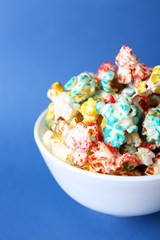 Sweet colourful popcorn on blue background
