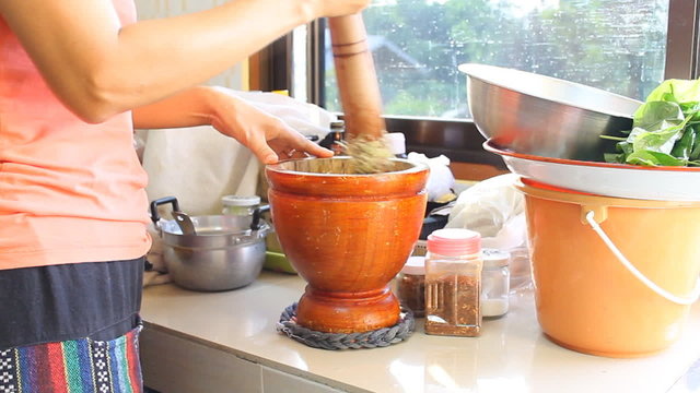 Easy Thai papaya salad cooking in kitchen by wood mortar.