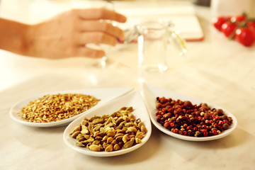 Variety of spices in ceramic containers on the kitchen table