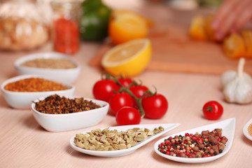 Variety of spices in ceramic containers on the kitchen table