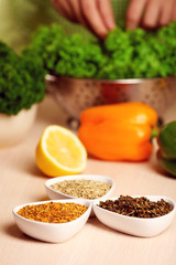 Variety of spices in ceramic containers on the kitchen table