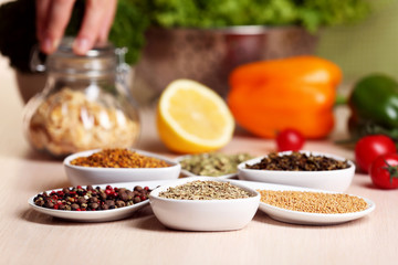 Variety of spices in ceramic containers on the kitchen table