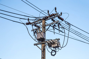 Transformer and power lines on electric pole with sky background
