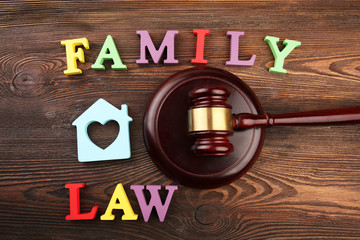 A gavel, a silhouette of a house and colourful letters regarding child-custody and family-law concept