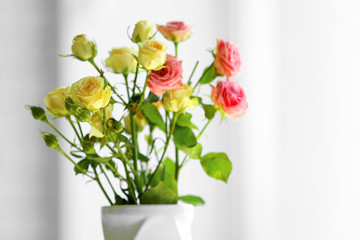 Beautiful spring flowers in vase on window background