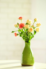 Beautiful spring flowers in vase on window background