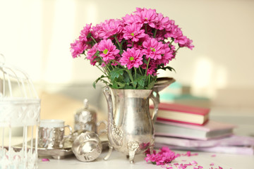 Beautiful flowers in vase on table in room