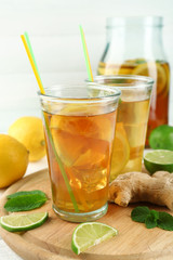 Iced tea with lemon on light wooden background