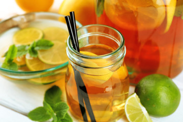 Iced tea with lemon on light wooden background