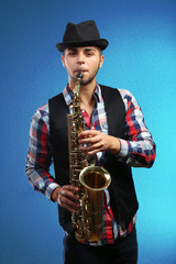 Obraz na płótnie Canvas Saxophone player on blue background