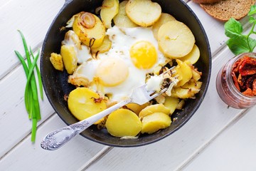 Fried potatoes with fried eggs, breakfast