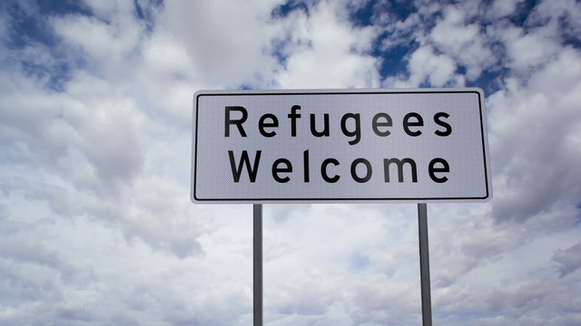 Highway road sign with the words refugees welcome written on it with a time-lapse clouds background.