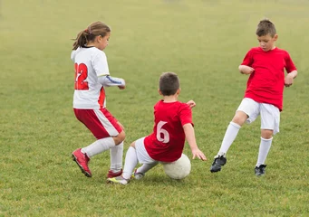 Deurstickers kids kicking football © Dusan Kostic