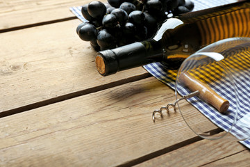 Obraz premium Bottle of wine and grape on wooden table