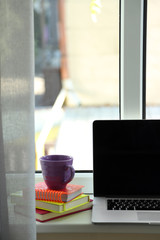 Desktop with notebook on windowsill