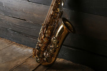 Beautiful golden saxophone on wooden background, close up