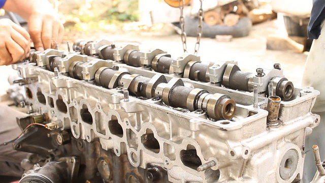 Installation camshaft on cylinder head of engine. Engine overhaul by professional technician.