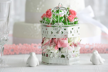 Flowers in cage and birds on wedding cake background