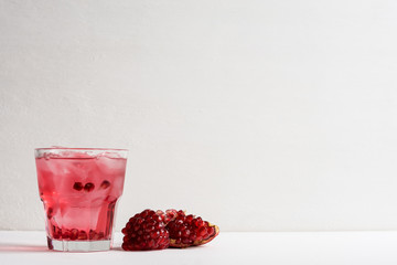 Delicious pomegranate cocktail on the white wooden background