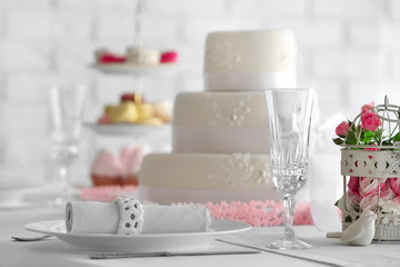 Wedding layered cake on decorated table in restaurant