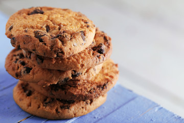 Cookies with chocolate crumbs on blue wooden table against blurred background, close up