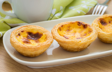 Egg tart on plate and tea cup