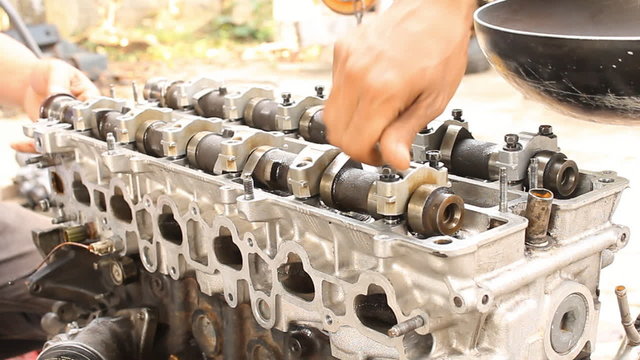 Installation camshaft on cylinder head of engine. Engine overhaul by professional mechanic.
