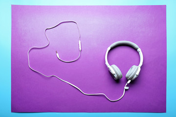 White and grey headphones on purple-blue background