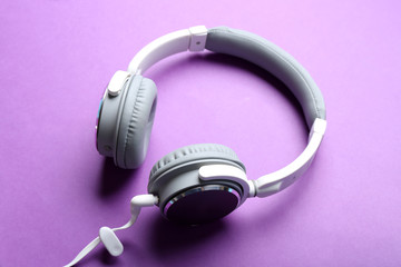 Fototapeta na wymiar White and grey headphones on purple background