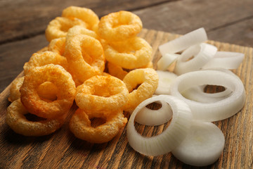 Naklejka premium Chips rings with sauce and onion on cutting board