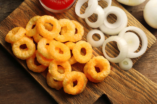 Chips rings with sauce and onion on cutting board