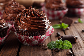 Chocolate cupcakes on wooden background closeup