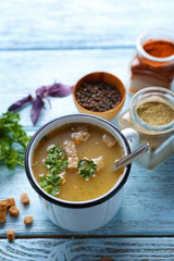 Mug of soup on blue wooden background