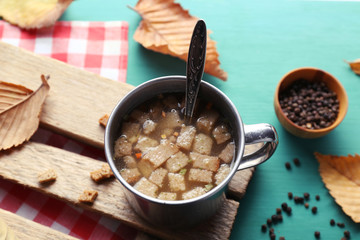 Mug of soup on wooden mat