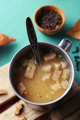 Mug of soup on wooden mat